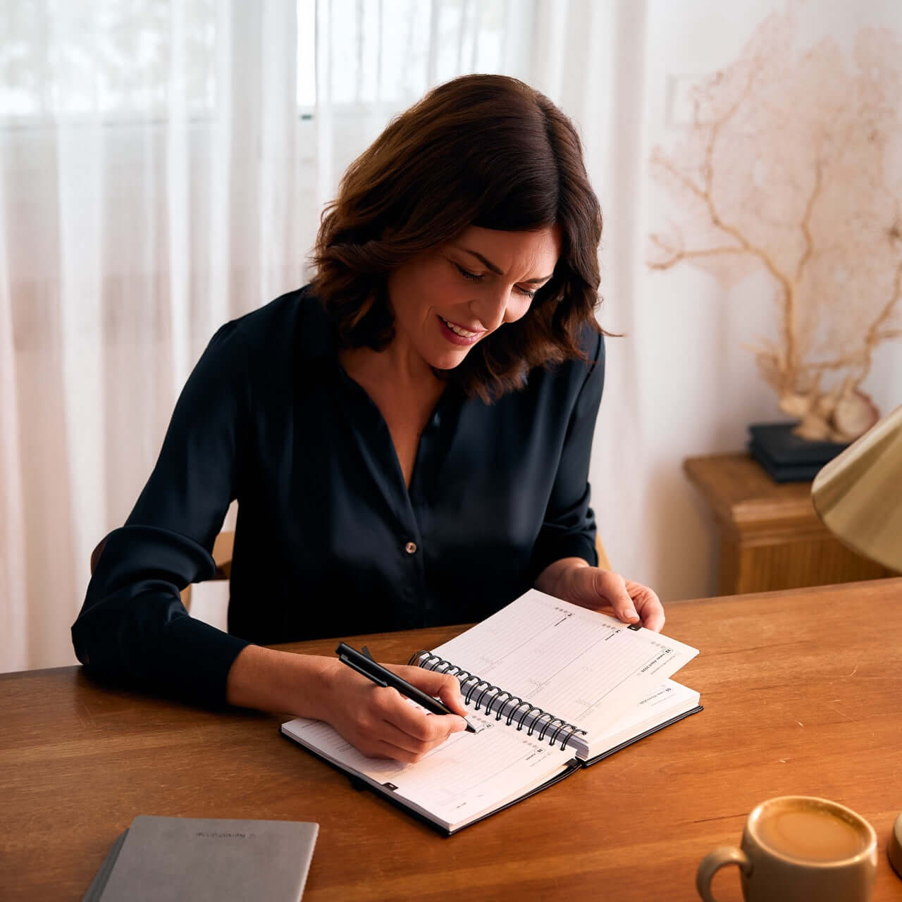 mujer utilizando boligrafo metalico negro premium northplanner para notas en agenda